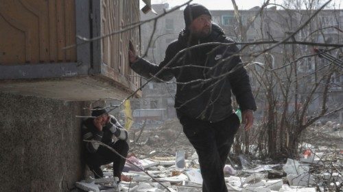 Local residents take cover as they hear blasts during Ukraine-Russia conflict in the besieged ...