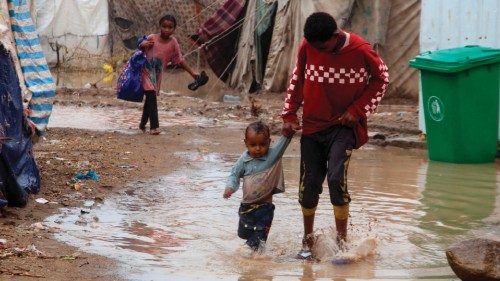 Children walk in flood water outside tents damaged by torrential rain, at a camp for internally ... Children walk in flood water outside tents damaged by torrential rain, at a camp for internally ...