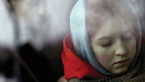 A tear drop rolls down a young woman's cheek onboard a bus after fleeing from Ukraine to Romania, ...