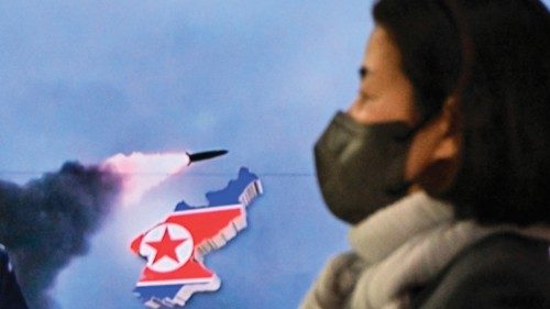A woman walks past a television report showing a news broadcast with file footage of a North Korean ... A woman walks past a television report showing a news broadcast with file footage of a North Korean ...