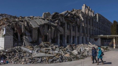 epaselect epa09839466 People walk past a severely damaged school after the Russian shelling, in ... epaselect epa09839466 People walk past a severely damaged school after the Russian shelling, in ...