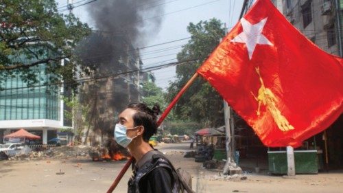 FILE PHOTO: A man holds a National League for Democracy (NLD) flag during a protest against the ...