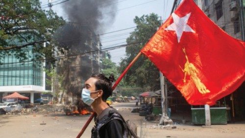 FILE PHOTO: A man holds a National League for Democracy (NLD) flag during a protest against the ... FILE PHOTO: A man holds a National League for Democracy (NLD) flag during a protest against the ...