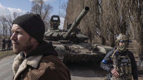 Ukranian servicemen walk past a Russian tank captured after fighting with Russian troops in the ... Ukranian servicemen walk past a Russian tank captured after fighting with Russian troops in the ...