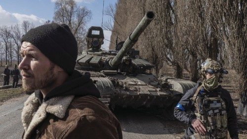 Ukranian servicemen walk past a Russian tank captured after fighting with Russian troops in the ...