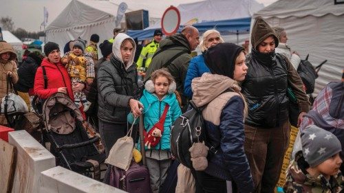 Ukrainian evacuees queue as they wait for further transport at the Medyka border crossing, after ...