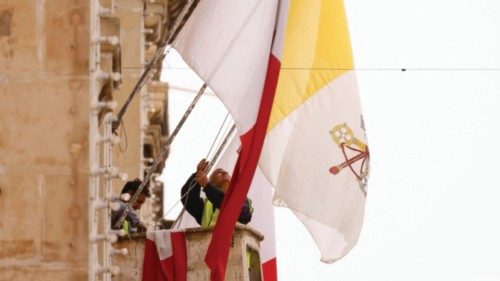 Workers hang flags of Malta and Vatican City during preparations for Pope Francis' upcoming visit to ...
