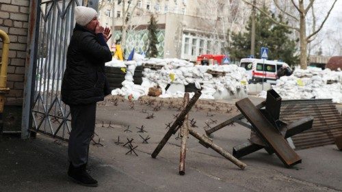 FILE PHOTO: A woman cries as she waits for news of her relative, in front of a destroyed Ukrainian ...