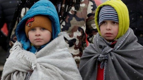 Two Ukrainian children, wearing blankets on their shoulders, pass through the border crossing of ... Two Ukrainian children, wearing blankets on their shoulders, pass through the border crossing of ...