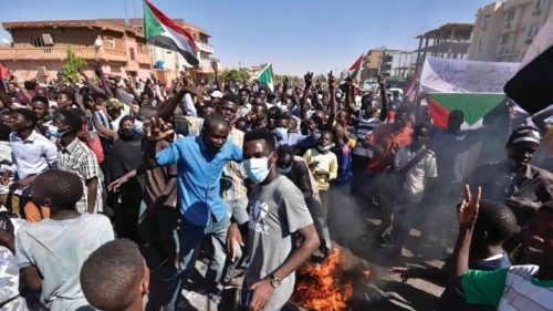 People gather with Sudanese national flagas as they protest against the military coup in Sudan, in ...