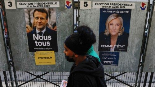 FILE PHOTO: People walk past official campaign posters of French presidential election candidates ...