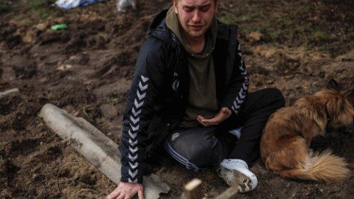 Serhii Lahovskyi, 26, mourns next to the grave of his friend Ihor Lytvynenko, who according to ...