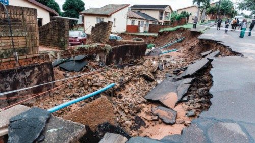 A general view of a severely damaged home and a crack in the road following heavy rains and winds in ...