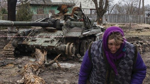 A woman walks past a destroyed Russian tank, as Russia's invasion of Ukraine continues, in the ...