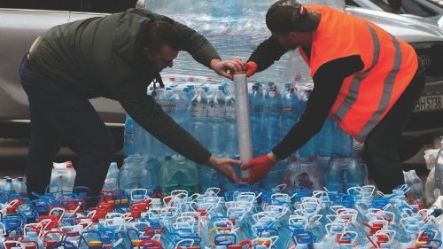 People wrap bottled drinking water in a humanitarian centre in Odessa on April 18, 2022. - The water ...