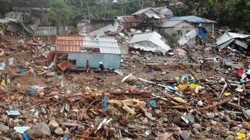 TOPSHOT - An aerial view shows residents walking past destroyed houses in the village of Pilar, ...