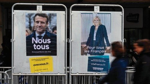 People walk past posters of far-right Party (RN) presidential candidate Marine Le Pen (R), and ...