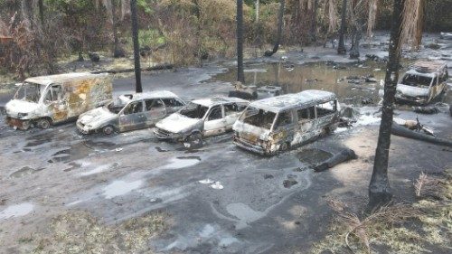 epa09907495 An aerial view taken with a drone shows burned bodies and cars at an illegal oil ...