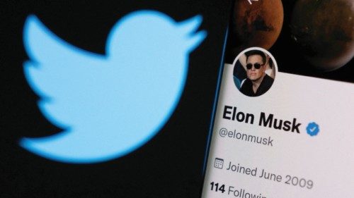 FILE PHOTO: Elon Musk's twitter account is seen on a smartphone in front of the Twitter logo in this ...