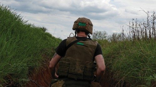 A Ukrainian serviceman walks in a trench, as Russia's attack on Ukraine continues, in Donetsk ...