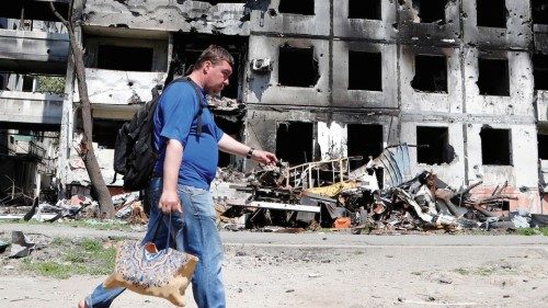 A man walks past a residential building, which was destroyed during Ukraine-Russia conflict in the ...