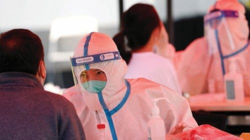 Medical workers in protective suits collect swabs from residents at a makeshift nucleic acid testing ...