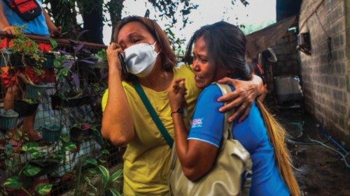 Relatives grieve the loss of loved ones after a fire at an informal settlement inside the campus of ...