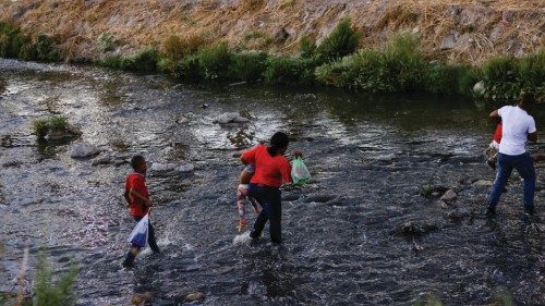 Asylum-seeking migrants cross the Rio Bravo river to turn themselves in to U.S Border Patrol agents ...