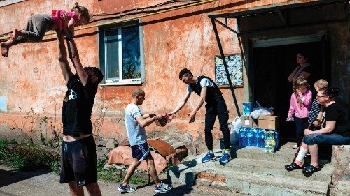 Nazar Tishchenko (L), Alexii(C) and Oleg Vadimovich (R) deliver humanitarian aid to a family in a ...
