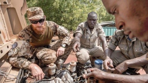 FILE PHOTO: A German army Bundeswehr instructor speaks to Mali soldiers during a car repair training ...