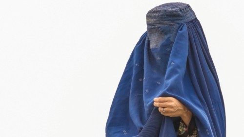 epa09414570 An Afghan burqa-clad women from northern provinces stands near her shelter after she ...