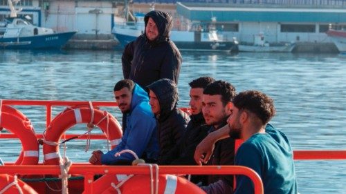 epa09933183 Red Cross members help some of the 19 Sub-Saharian migrants in the dock of Motril, ...