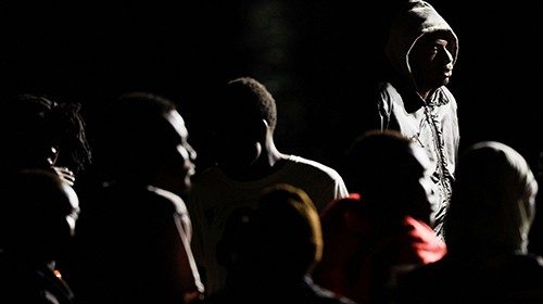 Migrants wait to disembark from a Spanish coast guard vessel, in the port of Arguineguin, in the ...