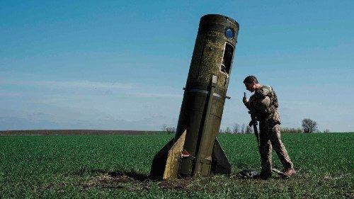 TOPSHOT - A Ukrainian serviceman looks at a Russian ballistic missile's booster stage that fell in a ... TOPSHOT - A Ukrainian serviceman looks at a Russian ballistic missile's booster stage that fell in a ...