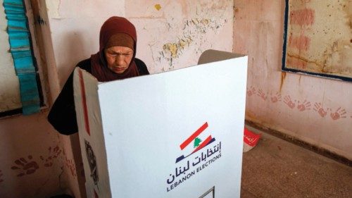 TOPSHOT - A woman ticks her ballot behind a privacy screen while voting in the parliamentary ...