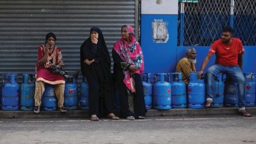 People sit on their empty cylinders as they wait in a queue to buy domestic gas at a distribution ... People sit on their empty cylinders as they wait in a queue to buy domestic gas at a distribution ...