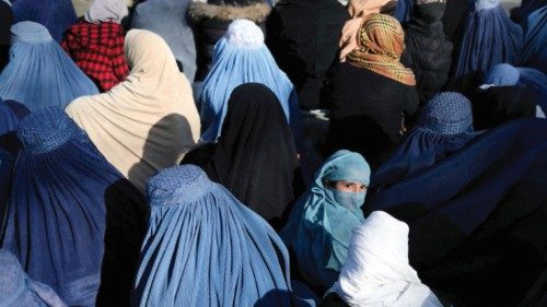 FILE PHOTO: A girl sits in front of a bakery in the crowd with Afghan women waiting to receive bread ...