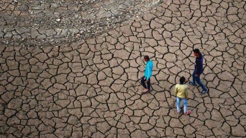 TOPSHOT - Youths walk along a dry river bed on the banks of the river Ganges, in Allahabad on ...