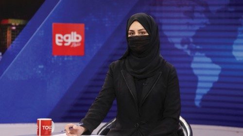 A female presenter for Tolo News, Khatereh Ahmadi, while covering her face, works in a newsroom at ...
