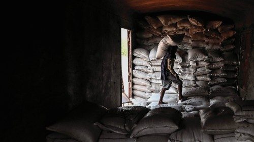 TOPSHOT - A worker loads a sack of wheat on a freight train at Chawa Pail railway station in Khanna, ...