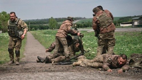 TOPSHOT - Ukrainian servicemen assist their comrades not far from the frontline in the eastern ...