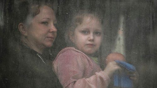 A mother with her daughter sit inside a bus as they evacuate the city of Bakhmut in the eastern ...