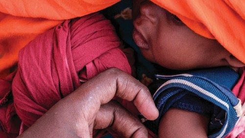 Health personnel measures the arm of an internally displaced child during a food distribution ...