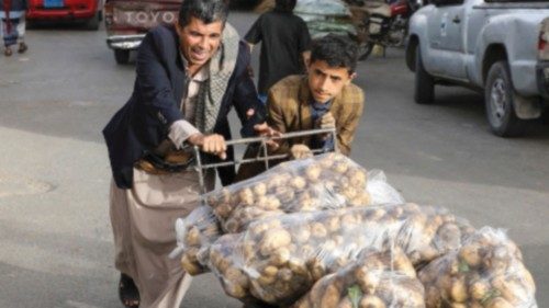 People push a wheel cart with bags of potato outside a market in Sanaa, Yemen May 19, 2022. Picture ...