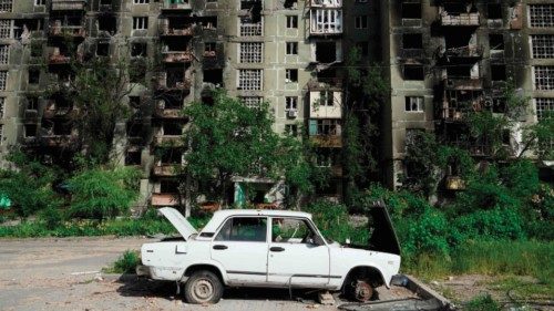 A damaged car is pictured in front of a destroyed residential building in Mariupol on May 31, 2022, ... A damaged car is pictured in front of a destroyed residential building in Mariupol on May 31, 2022, ...