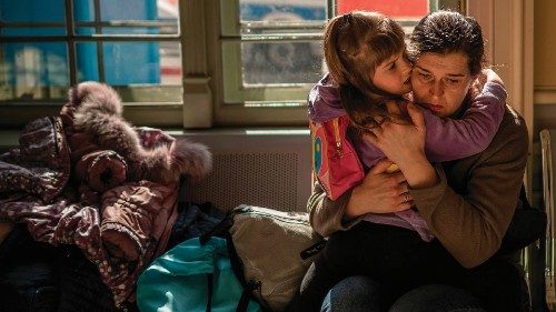 TOPSHOT - A Ukrainian evacuee hugs a child in the train station in Przemysl, near the ...