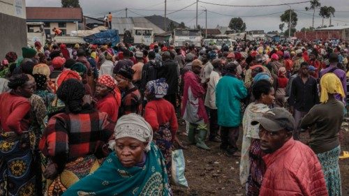 Displaced people who fled fighting between the Congolese army and the M23 in Kibumba wait for food ...