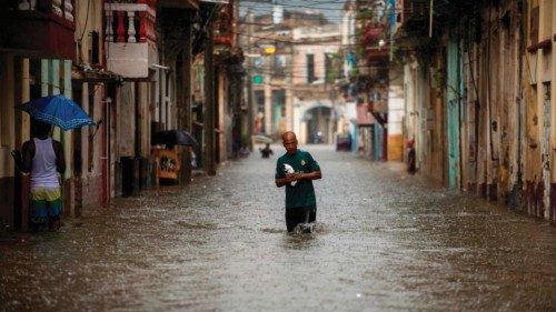 A man walks along a flooded street of Havana, on June 3, 2022. - The remnant of Hurricane Agatha is ...