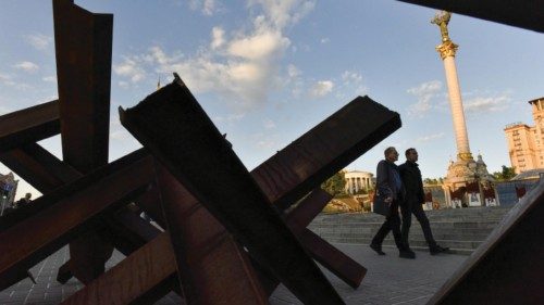 epa09973128 People walk past anti-tank hedgehogs at Maidan Nezhalezhnosti Square in Kyiv (Kiev), ...