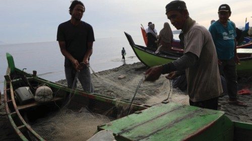 epa10001354 Fisherman pick their catch from a net in Banda Aceh, Indonesia, 08 June 2022. Aceh ...